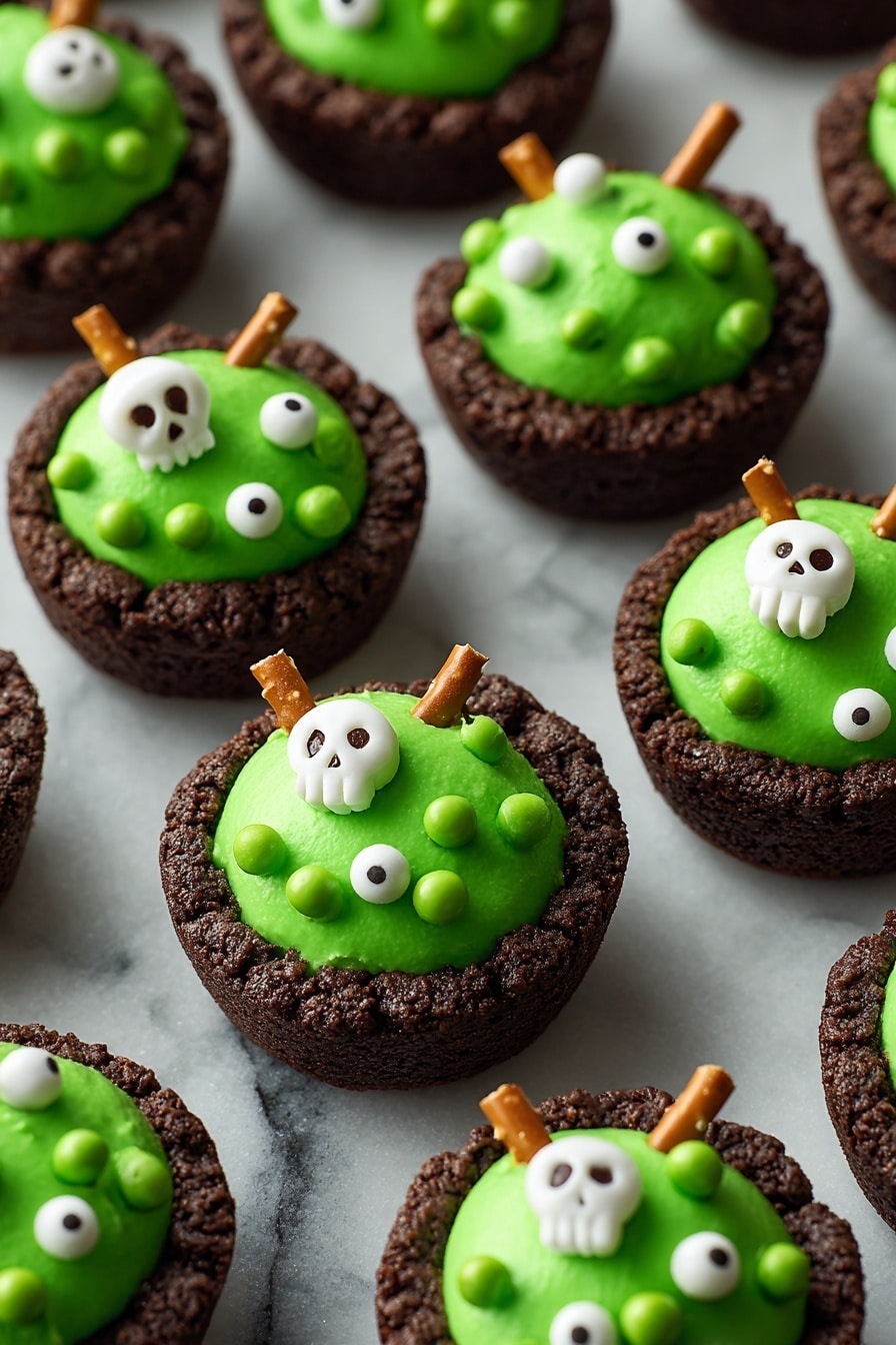 The image shows several dark brown cookie cups as the base layer, each with a thick, smooth, bright green frosting topped on them in a rounded mound shape. The green frosting is decorated with small white edible pearls, green candy balls, and white candy shapes like skulls and bones scattered across the surface. Some cookie cups have a single pretzel stick inserted vertically into the green frosting, adding a crunchy texture. All items are placed on a black tray with a close-up focus, and the background is a white marbled texture. photo taken with an iphone --ar 2:3 --v 7 - Cauldron Cookie Cups, Halloween cookie treats, chocolate cookie cups, festive dessert ideas, spooky party desserts
