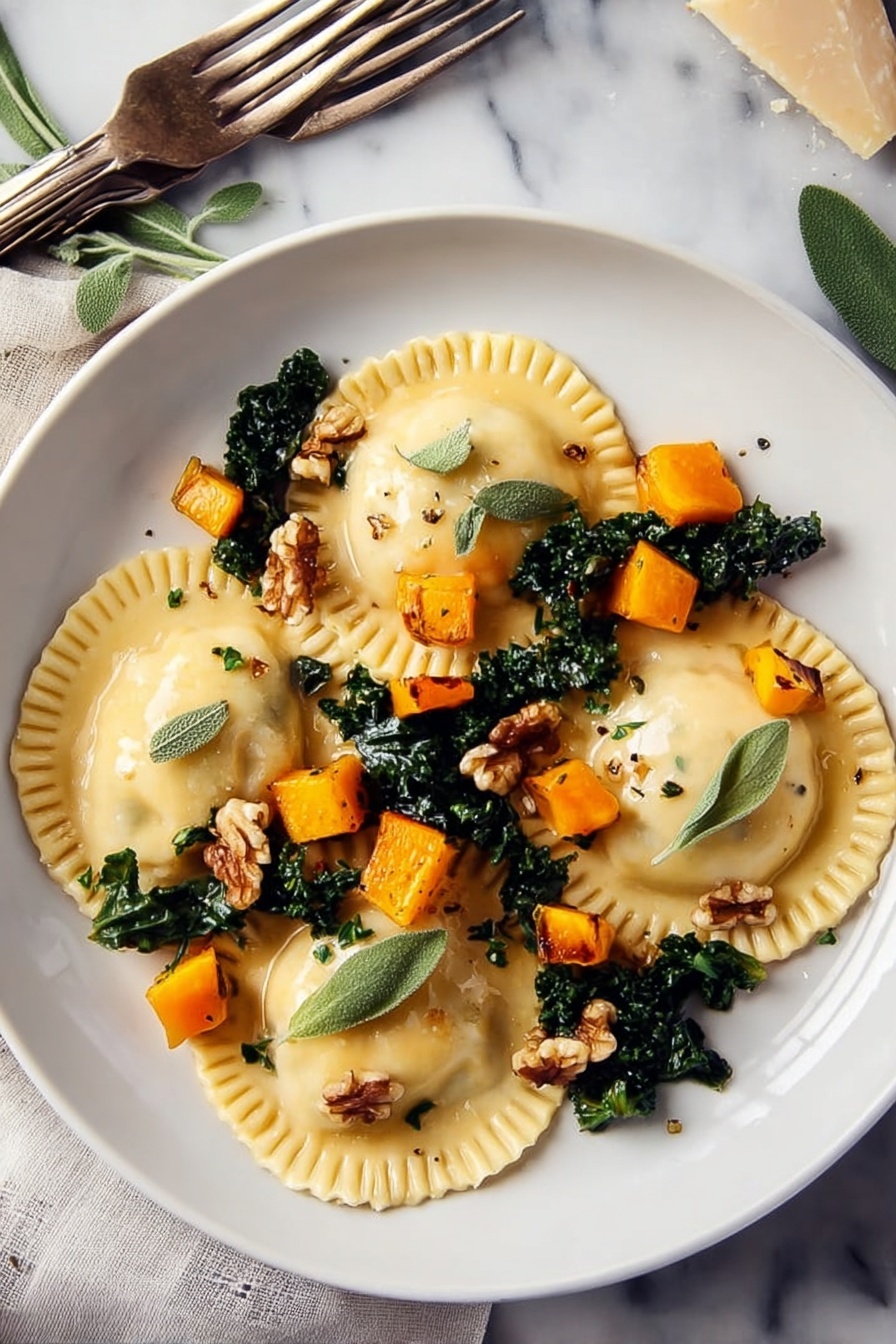 Two white plates on a white marbled surface each hold three large ravioli pieces. The ravioli are light yellow with crimped edges, placed over dark green cooked kale leaves. Small, bright orange cubes of roasted squash are scattered on top along with a few light brown walnut pieces. Fresh green sage leaves and tiny thyme leaves are sprinkled over the dish. One plate has a black-handled fork and a silver knife resting on it, while another fork with a beige handle lies on the surface nearby. To the left, a small wooden dish holds extra walnuts, next to two glass jars—one with olive oil and one with white vinegar. Fresh sage sprigs and a blue cloth napkin are around the plates. photo taken with an iphone --ar 2:3 --v 7 - Butternut Squash Ravioli with Sage Walnut Sauce, homemade ravioli recipes, fall pasta recipes, seasonal squash pasta, vegetarian ravioli dishes