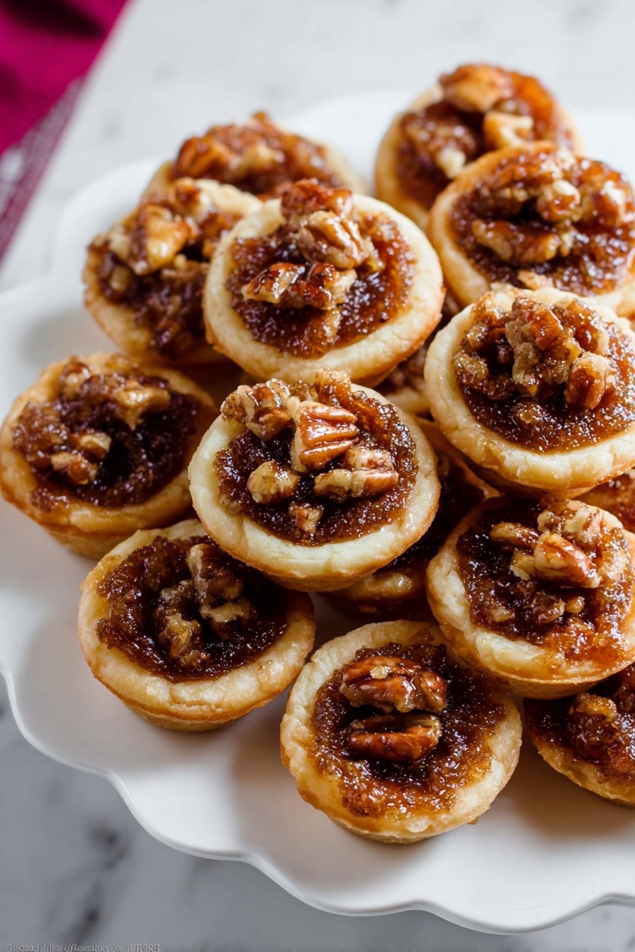 The image shows several small tartlets placed on a white marbled surface. Each tartlet has a golden-brown short crust base that looks crisp. Inside, there is a rich, bubbly filling made of dark brown caramelized nuts, mainly walnuts, giving a textured and slightly glossy look. The top layer is sprinkled with coarse white salt crystals, adding contrast and highlighting the nut filling. The tartlets are close together, showing a rustic and homemade feel with uneven edges and a warm, inviting color mix of golden crust and dark filling. photo taken with an iphone --ar 2:3 --v 7 - Mini Pecan Pies in a Mini Muffin Pan, easy pecan pie bites, individual pecan dessert, holiday mini pies, bite-sized pecan treats