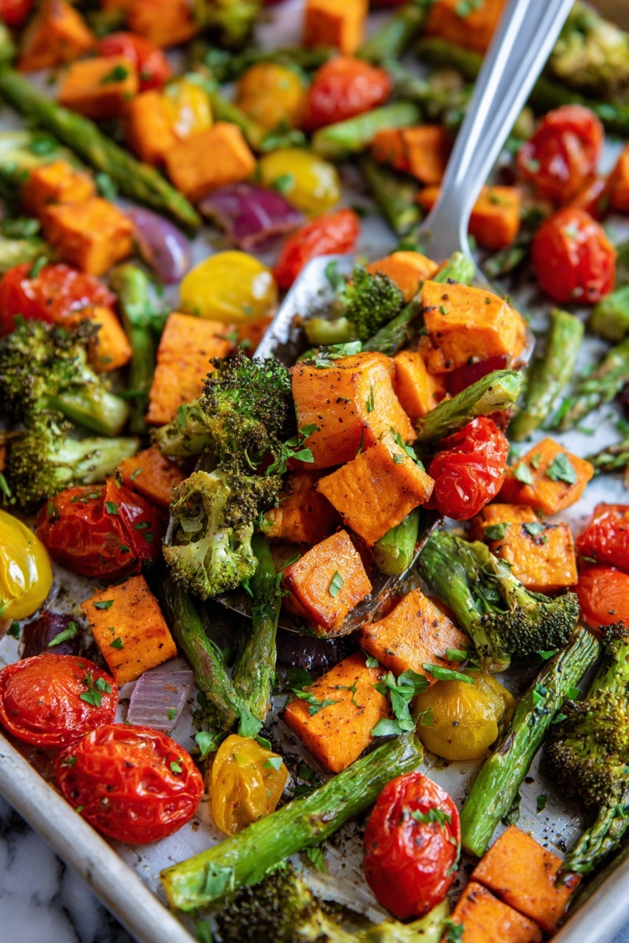 This image shows a close-up of a tray filled with roasted vegetables in layers. The first layer has bright orange sweet potato chunks with a slightly crispy texture. The second layer is made up of green asparagus spears and small broccoli pieces with roasted edges. The third layer consists of red and yellow cherry tomatoes, some whole and some cut in half showing their juicy inside. The vegetables are mixed together with small green herb leaves sprinkled on top. The background surface is a white marbled texture. A metal spatula is lifting a mix of these vegetables in the center of the image, with a woman's hand partly visible on the side. photo taken with an iphone --ar 2:3 --v 7 - Sheet Pan Roasted Vegetables, roasted vegetable recipes, easy vegetable side dish, healthy roasted vegetables, colorful roasted veggies