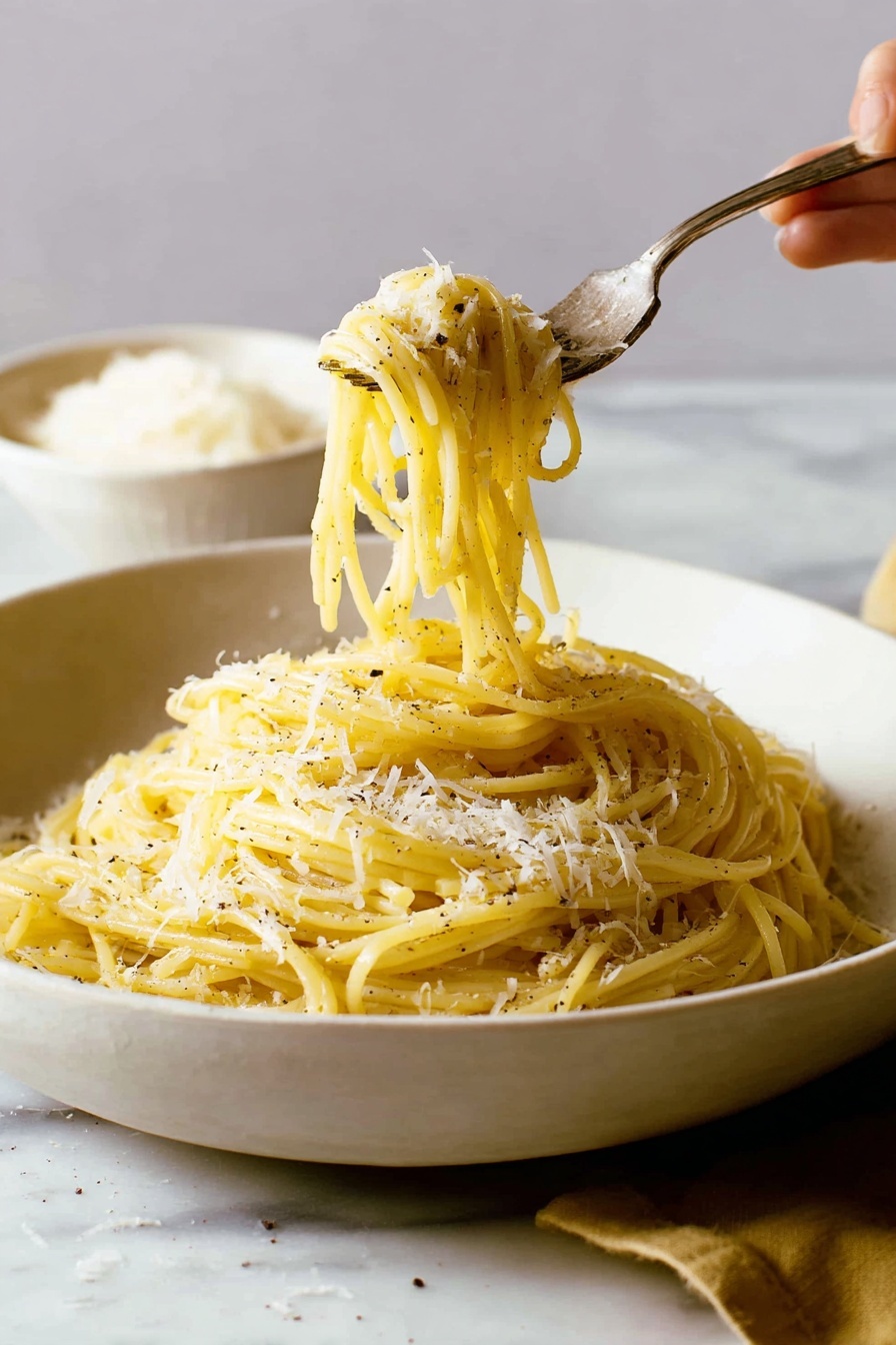 A white, shallow bowl filled with a pile of yellowish spaghetti pasta, sprinkled with small patches of grated white cheese and black pepper. The pasta strands have a smooth and slightly shiny texture, twisted around a silver fork that a woman's hand is lifting from the bowl. The background and surface around the bowl have a white marbled texture, with a blurred white bowl of grated cheese in the back left side. The scene is softly lit, showing a warm and cozy feel. photo taken with an iphone --ar 2:3 --v 7 - Cacio e Pepe Pasta, Italian pasta dishes, simple pasta recipes, creamy pepper pasta, quick Roman pasta dishes