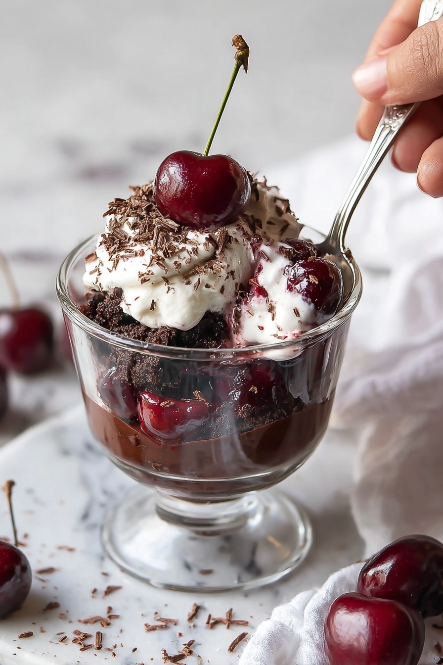 A glass trifle dish holds a layered dessert starting with a dark chocolate crumb base at the bottom, followed by a thick chocolate pudding layer. Above this is a white cream layer with swirls of red cherry sauce, then another dark chocolate crumb layer, and a second thick chocolate pudding layer. The top is covered with glossy cherry sauce and a generous layer of fluffy white whipped cream sprinkled with tiny chocolate shavings. Several fresh cherries with green stems sit on top, adding a shiny red contrast. The dish is on a white marbled surface with a small white bowl of chocolate shavings nearby, photo taken with an iphone --ar 2:3 --v 7 - Black Forest Cherry Trifle, cherry chocolate dessert, layered dessert recipe, easy trifle ideas, holiday dessert recipes