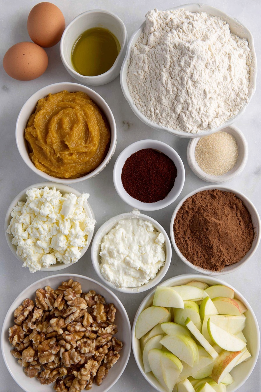 Flat lay of fresh all purpose flour in a small mound, a few brown eggs with smooth uncracked shells, a glistening golden olive oil pool in a small white ceramic bowl, vibrant orange pumpkin puree in a small white bowl, creamy white ricotta cheese dollop in a small white bowl, finely grated pale parmesan cheese in a small white bowl, rustic brown sugar crystals in a small white bowl, ground cinnamon and allspice powders gently mounded side by side, bright red cayenne powder in a small white bowl, lightly cracked black pepper powder, a handful of fresh bright green sage leaves, diced Gala apple pieces showing red and cream hues in a small white bowl, small white bowl with pale apple cider vinegar, chopped walnuts with rough textured surface in a small white bowl, fresh uncooked sheet of pale ravioli dough laid flat with clean edges — no utensils or packaging, all ingredients arranged with perfect symmetry on a clean white marble surface, soft natural light, photo taken with an iPhone, professional food photography style, fresh ingredients, white ceramic bowls, no bottles, no duplicates, no utensils, no packaging --ar 2:3 --v 7 --p m7354615311229779997 - Pumpkin Ravioli with Apple Sage Butter, autumn pasta recipes, homemade pumpkin ravioli, fall comfort food, sage butter pasta