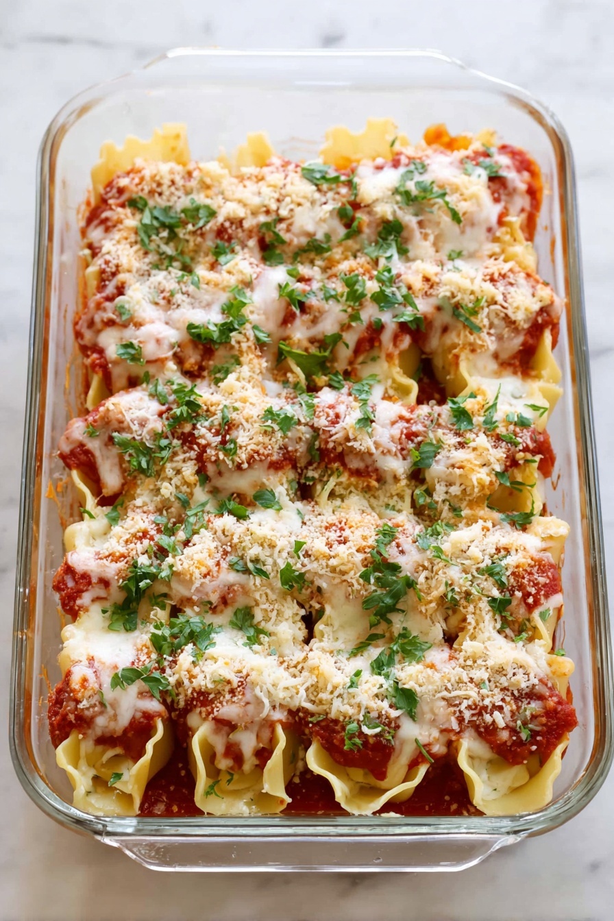 Three large pasta shells are arranged on a white plate with tomato sauce spread beneath them. Each shell is filled with a white cheese filling, topped with a layer of melted cheese that looks soft and lightly browned. A sprinkle of light brown breadcrumbs sits on top of the melted cheese, and fresh green parsley leaves are scattered over and around the shells, adding a bright touch. The plate rests on a white marbled surface. photo taken with an iphone --ar 2:3 --v 7 - Chicken Parmesan Stuffed Shells, Italian stuffed shells, cheesy chicken pasta, baked stuffed shells, easy chicken shell recipe