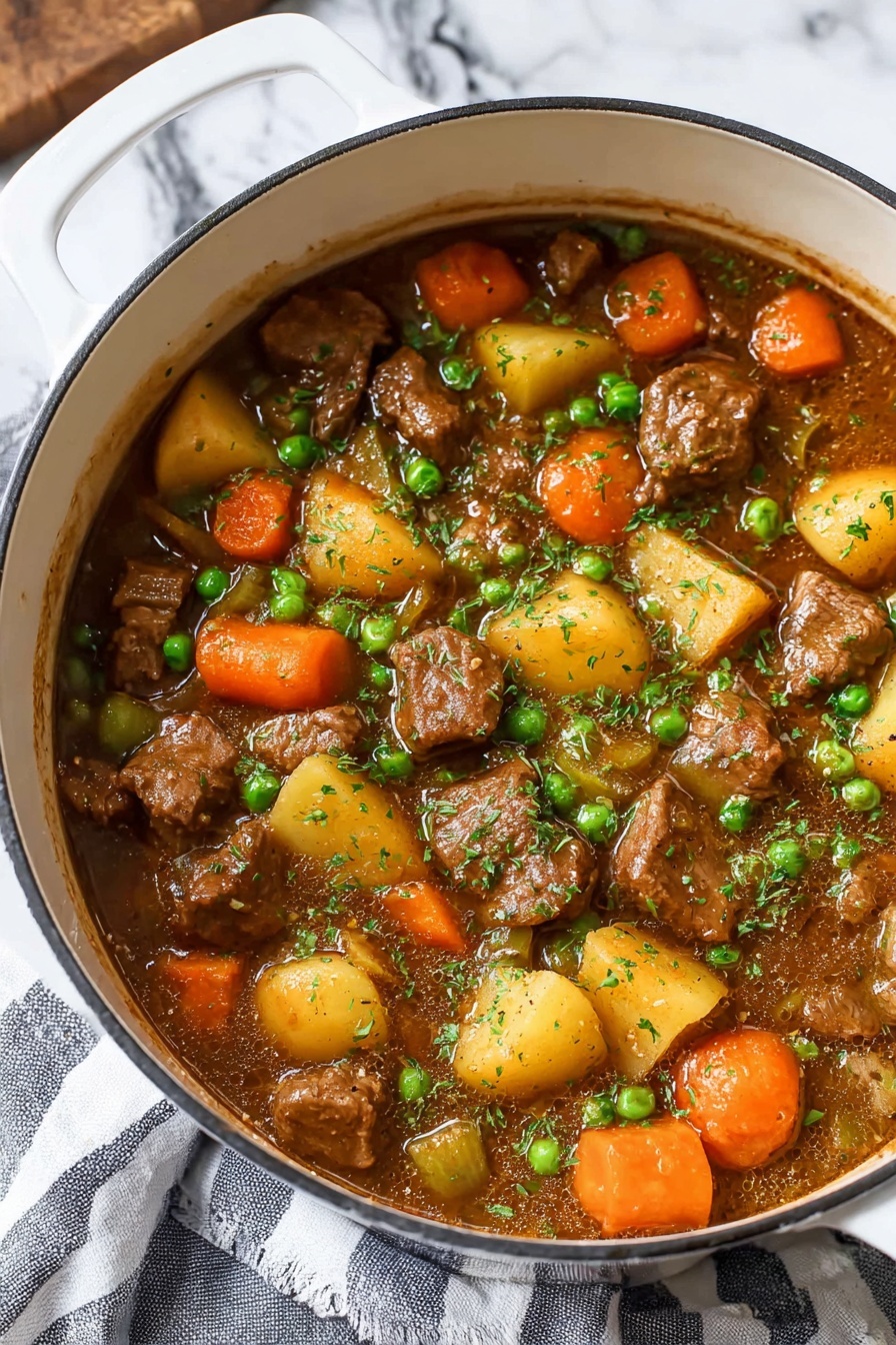 A white pot filled with a thick stew showing several layers: large chunks of brown meat, round orange carrot slices, yellow potato pieces, small green peas, and diced celery, all mixed in a rich brown sauce and lightly sprinkled with chopped green herbs on top. The pot sits on a white marbled surface with a striped gray and white cloth partially visible underneath. The colors of the stew ingredients contrast brightly with the white pot, making the dish look warm and hearty photo taken with an iphone --ar 2:3 --v 7 - Hearty Beef Stew, beef stew recipe, comforting beef stew, easy beef stew, homemade beef stew
