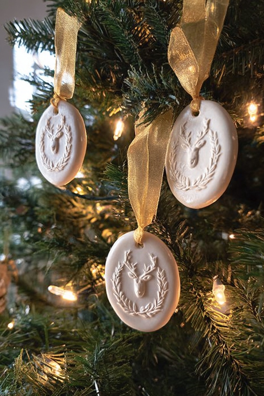 The image shows a Christmas tree decorated with three white oval ornaments, each with a raised design featuring a reindeer head surrounded by a laurel wreath. Each ornament is hung with a shiny golden ribbon tied in a simple loop. The tree has green needles with warm white string lights softly glowing around the ornaments, creating a cozy and festive look. The background is softly blurred, emphasizing the details and texture of the ornaments and the pine needles. photo taken with an iphone --ar 2:3 --v 7 - Springerle Cookie, German Springerle Cookies, Anise-Flavored Cookies, Traditional German Cookies, Holiday Baking Cookies