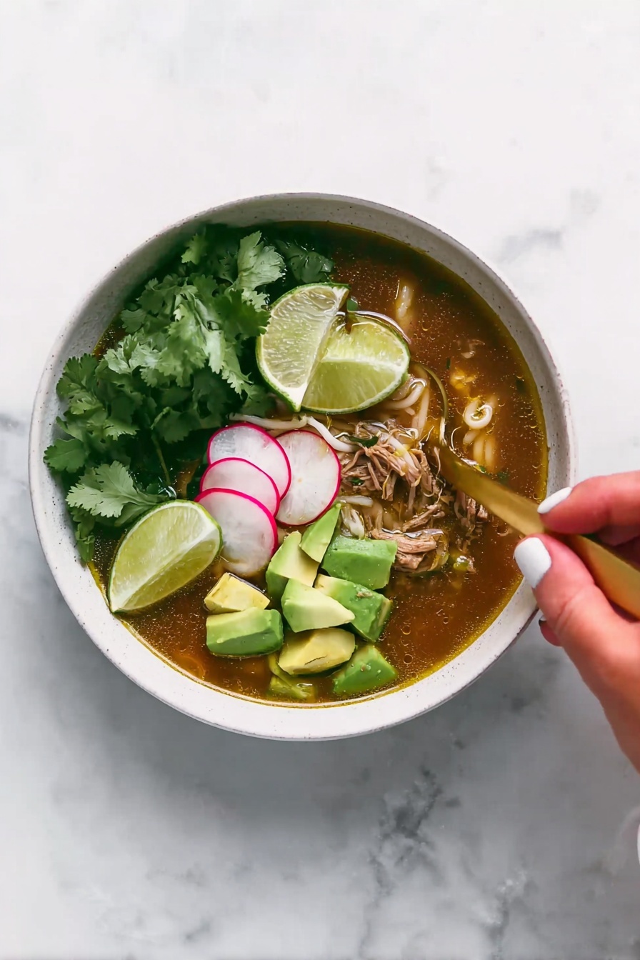 A white bowl filled with soup that has a brownish broth at the bottom layer mixed with pieces of shredded meat and small white noodles. On top of the soup, there are bright green chunks of avocado stacked on one side and thin slices of radish with a pale pink color beside them. Fresh green cilantro leaves are also scattered over the soup. A gold spoon is placed inside the bowl, partially submerged in the broth. Above the bowl, a woman's hand holding a lime wedge is about to squeeze it into the soup. The surface beneath the bowl is a white marbled texture. photo taken with an iphone --ar 2:3 --v 7 - Slow Cooker Chicken Posole Verde, Chicken Posole Verde, Posole Verde Recipe, Easy Posole Verde, Healthy Chicken Stew