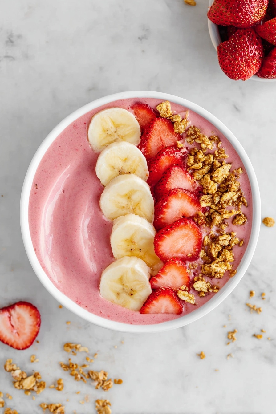 The image shows a white bowl filled with a smooth pink smoothie base. On top, there are three distinct layers arranged in a half-circle: a row of light yellow banana slices on the right, a line of bright red chopped strawberries next to the bananas, and small clusters of golden brown granola scattered over the strawberries. The bowl sits on a white marbled surface with small bits of granola scattered around. Photo taken with an iphone --ar 2:3 --v 7 - Healthy Strawberry Banana Smoothie Bowl, healthy breakfast recipes, easy smoothie bowl, nutritious fruit bowls, quick healthy snacks